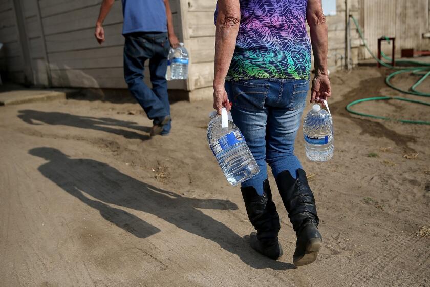 Drinking water is delivered in April to a resident in Porterville, Calif., which has no running water.