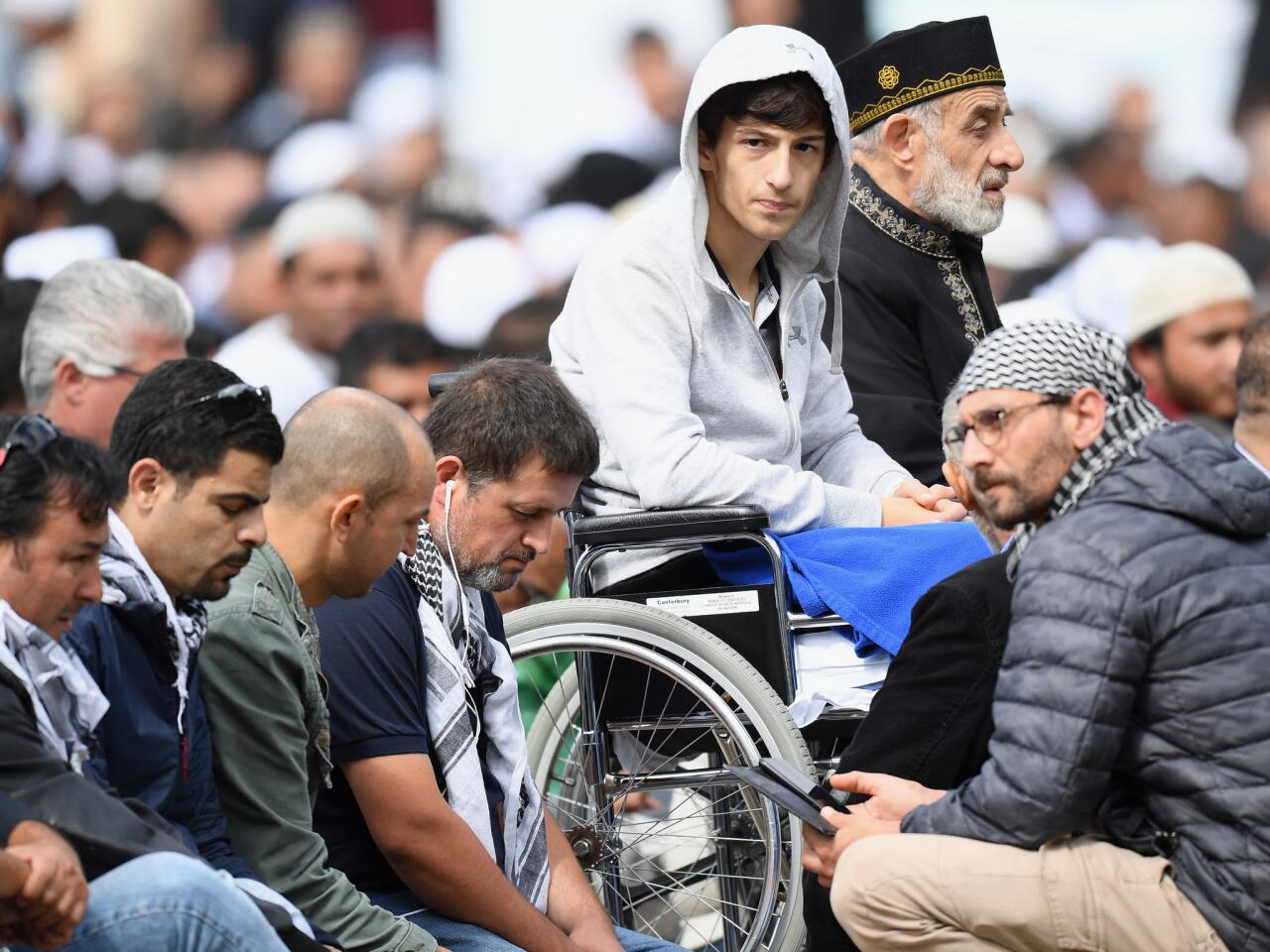 Zahid Mustafa, center, whose father Khaled Mustafa and brother Hamza Mustafa were killed at Al Noor mosque, attends Friday prayers in Hagley Park near Al Noor mosque in Christchurch, New Zealand.