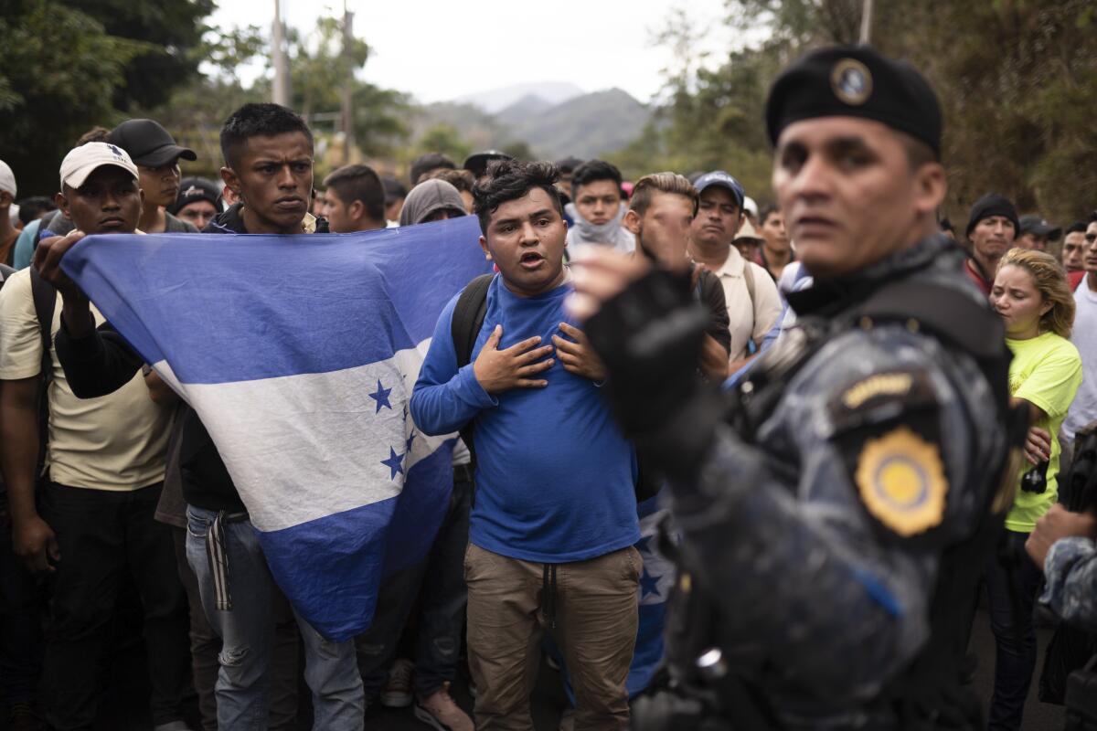 FILE - In this Jan. 16, 2020 file photo, Honduran migrants hoping to reach the U.S. border are stopped by Guatemalan police near Agua Caliente, Guatemala, on the border with Honduras. The reasons Hondurans continue to flee their country have been well documented: pervasive violence, deep-seated corruption, lack of jobs and widespread destruction from two major hurricanes that struck the region last November. (AP Photo/Santiago Billy, File, File)