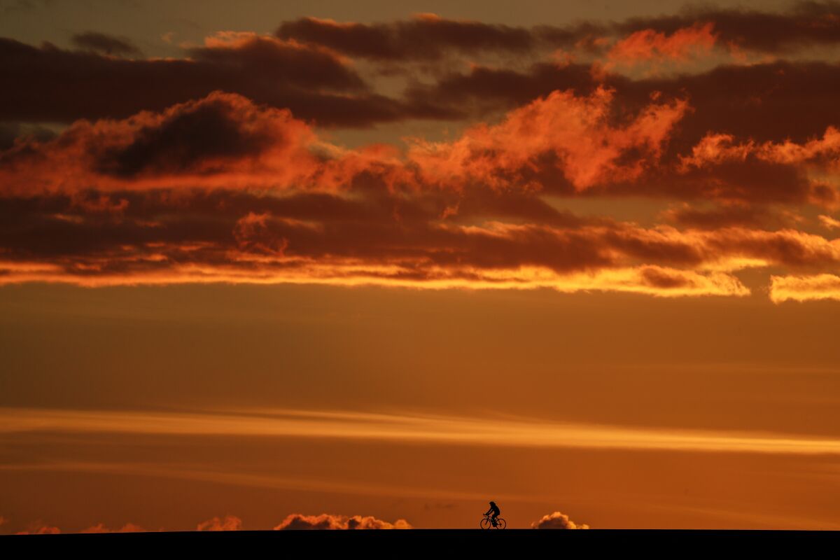 A yellow and orange sky above a cyclist