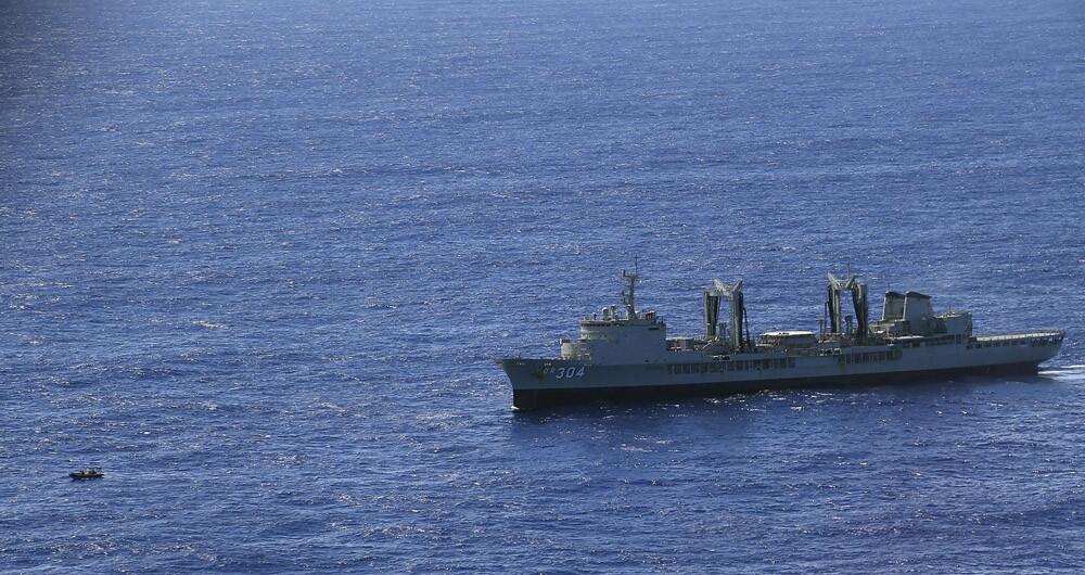 A small boat sails in front of the HMAS Success while searching for missing Malaysia Airlines flight MH370 on March 31.