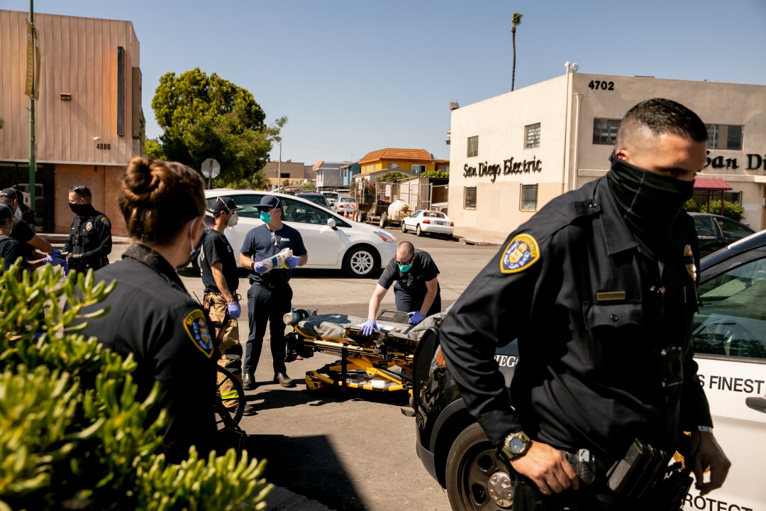 A handful of San Diego police officers and firefighters help a woman in distress.
