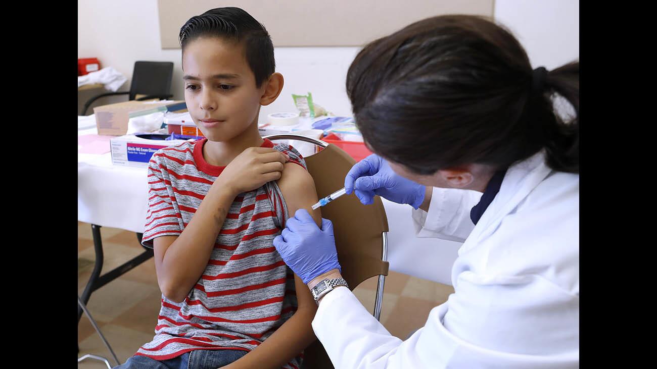 Bryan Olmedo, 11 of Glendale, gets the flu shot from L.A. County Dept. of Public health Glendale District public health nurse Ayda Keshishian at the annual Glendale Health Festival, at Pacific Edison Community Center in Glendale, on Saturday, Nov. 4, 2017.