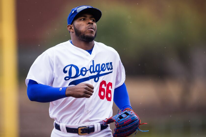 Yasiel Puig runs on the field while wearing a Dodgers uniform