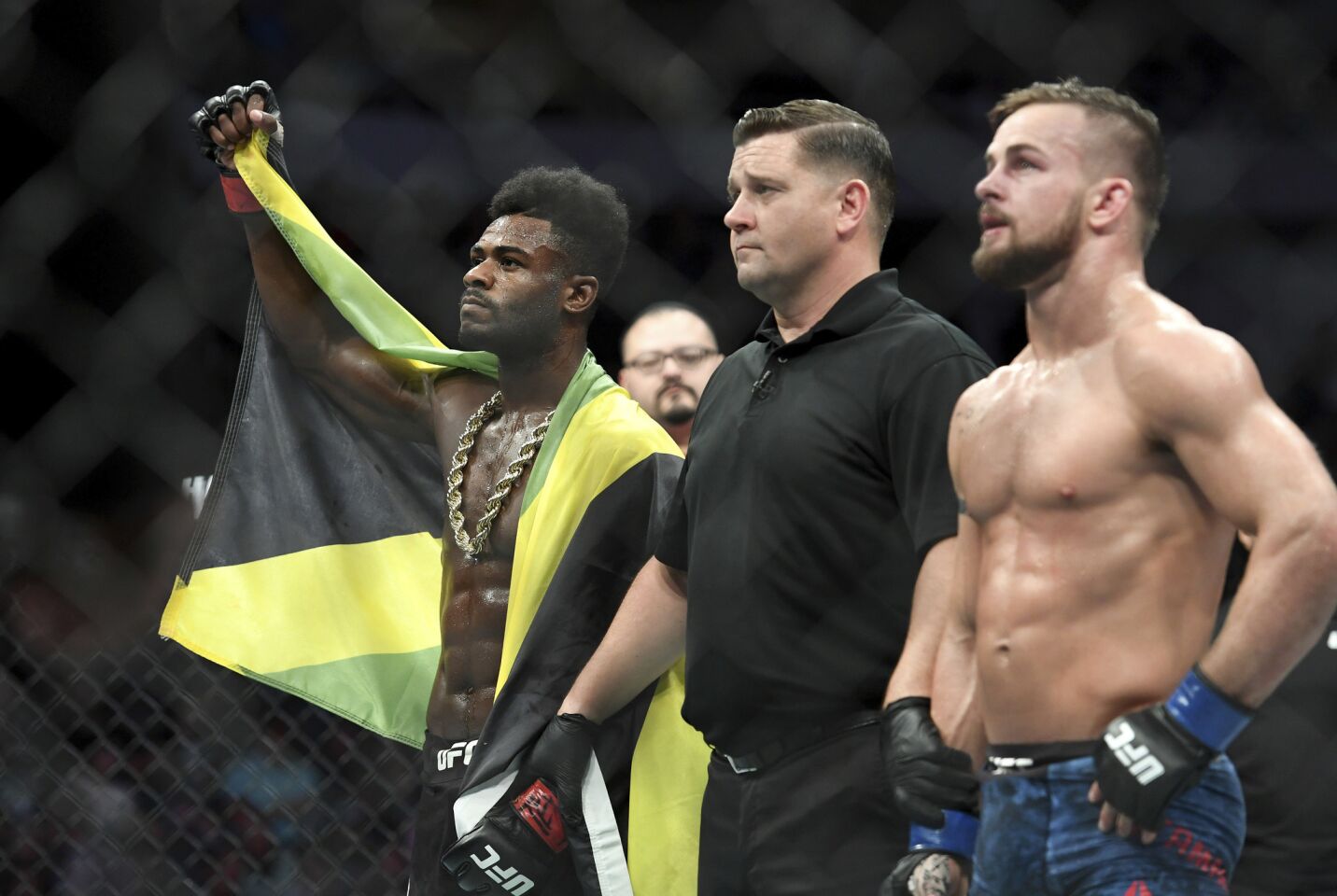 Aljamain Sterling, left, is acknowledged as the winner of his UFC welterweight mixed martial arts bout against Cody Stamann, right, at UFC 228 on Saturday, Sept. 8, 2018, in Dallas. (AP Photo/Jeffrey McWhorter)