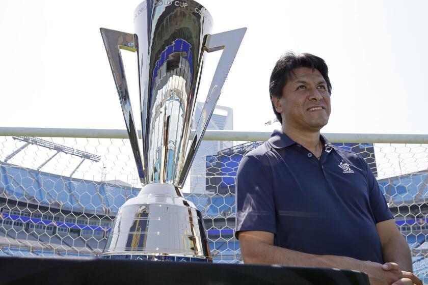 Mexican soccer legend Claudio Suarez leans next to the Gold Cup trophy at Bank of America Stadium in Charlotte, N.C. where matches are scheduled next week.