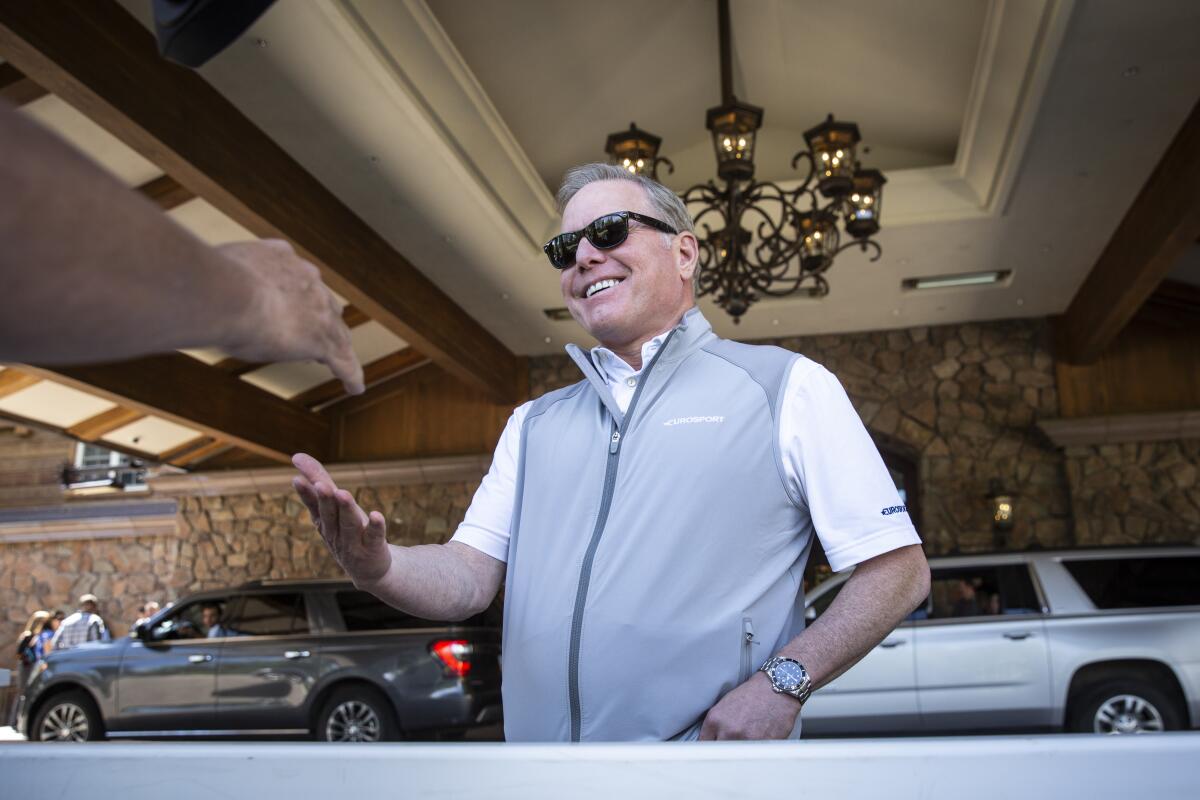 Discovery's David Zaslav in a polo shirt and sports vest in the flagstone entry of a hotel. 