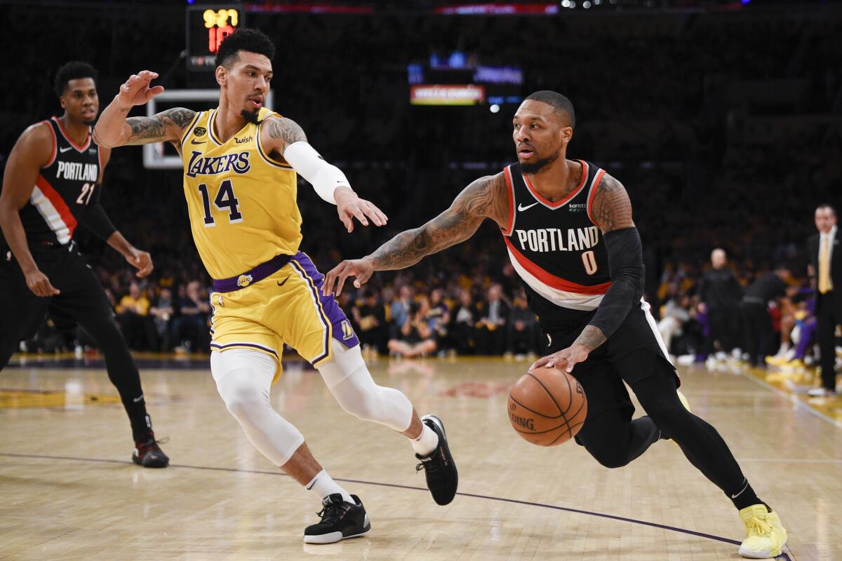 Portland guard Damian Lillard  drives to the basket in front of Lakers guard Danny Green during the Trail Blazers' win Friday.
