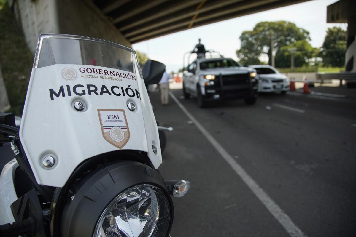 Mexican immigration officials work with National Guard soldiers at a check point 