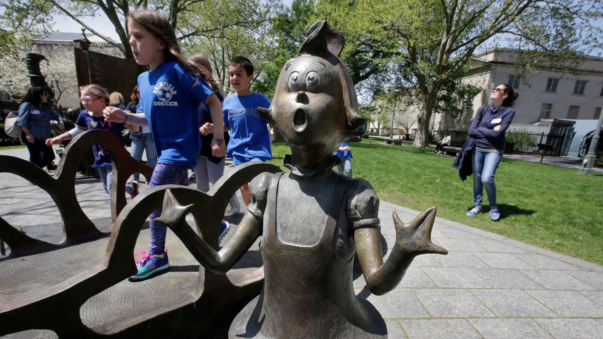 Children play near a bronze statue of a Seuss character at the Dr. Seuss National Memorial Sculpture Garden in Springfield, Mass.