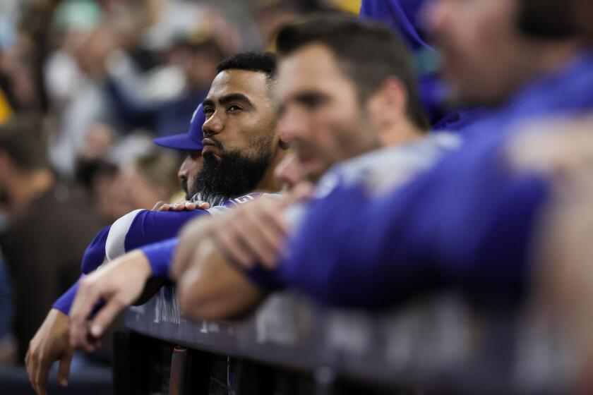 Teoscar Hernández watches from the dugout alongside his Dodgers teammates against the Padres at Petco Park.