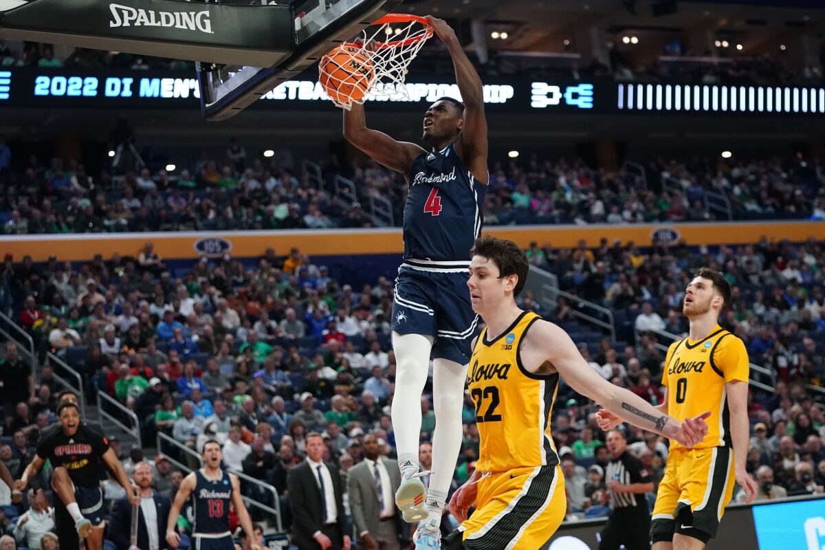 Richmond's Nathan Cayo dunks in front of Iowa's Patrick McCaffery and Filip Rebraca.
