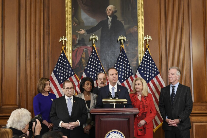 Rep. Adam B. Schiff (D-Burbank) is flanked by other House Democrats as he announces articles of impeachment against President Trump.