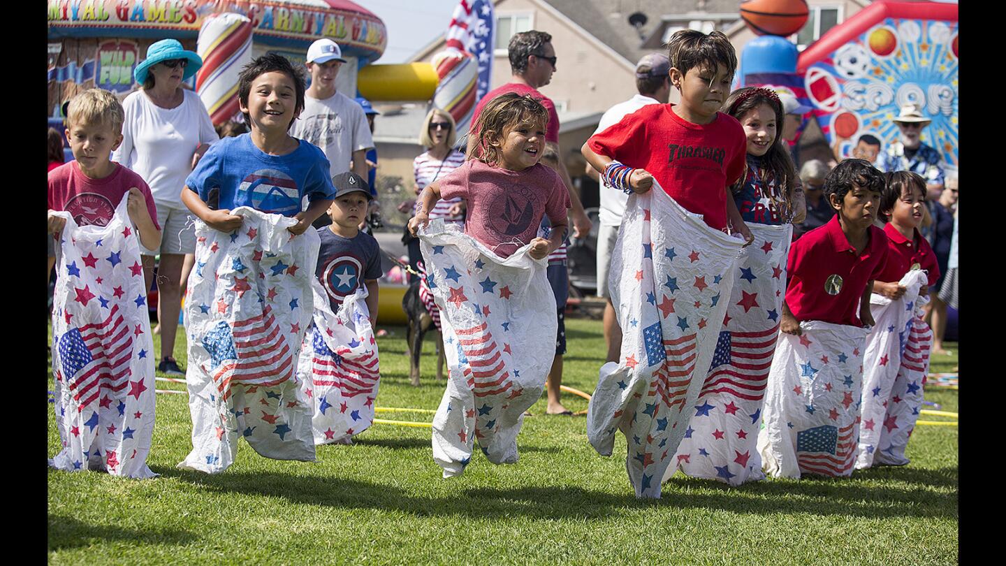 Children participate in a sack race during the annual Newport Peninsula Bike Parade and Community Festival on Tuesday, July 4.
