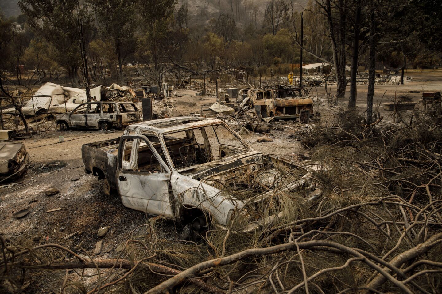 Burned out cars sit in the remains of a home that was destroyed by the Medocino Complex fire in Clearlake Oaks, Calif.