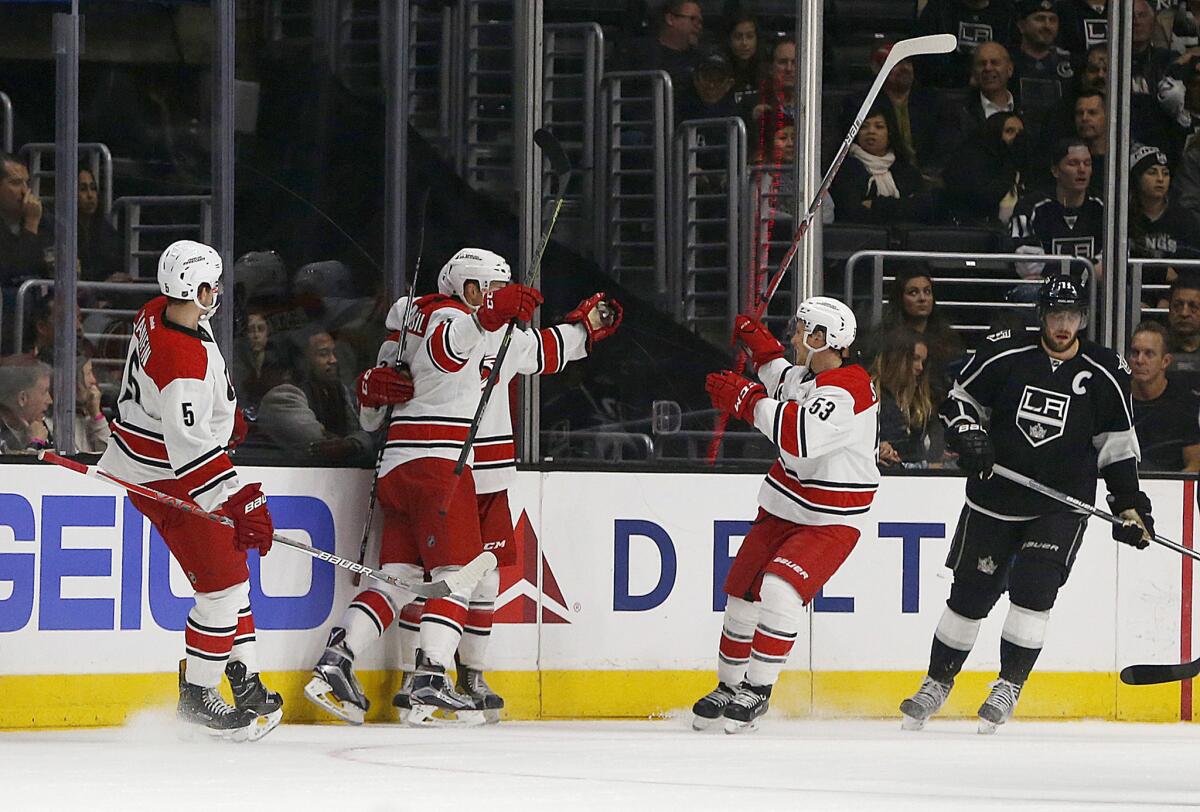 Kings center Anze Kopitar (11) skates away on the right as Carolina Hurricanes center Derek Ryan (33) celebrates his first goal of the game with teammates in the first period.