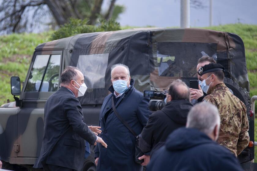 Anti-mafia Prosecutor Nicola Gratteri, left, stands by military personnel outside a specially constructed bunker on the occasion of the first hearing of a maxi-trial against more than 300 defendants of the ‘ndrangheta crime syndicate, near the Calabrian town of Lamezia Terme, southern Italy, Wednesday, Jan. 13, 2021. A maxi-trial opened Wednesday in southern Italy against the ‘ndrangheta crime syndicate, arguably the world's richest criminal organization that quietly amassed power in Italy as the Sicilian Mafia lost its influence. (Valeria Ferraro/LaPresse via AP)