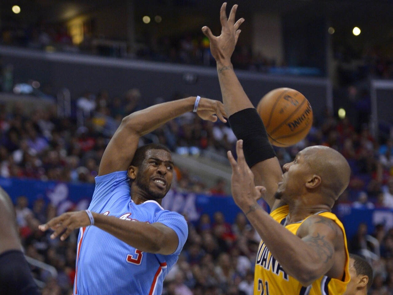 Clippers point guard Chris Paul flips a pass around Pacers power forward David West in the second half Sunday at Staples Center.