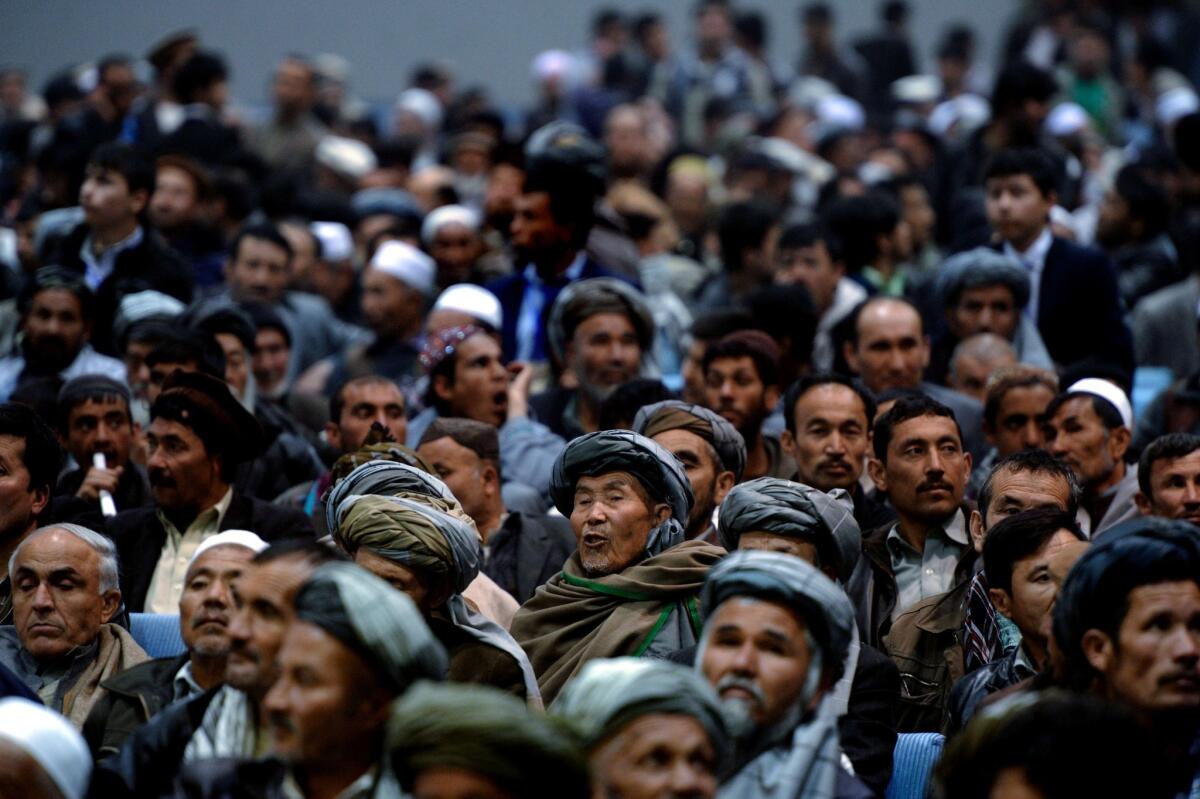 Afghan men fill a local hall in Kabul as they congregate to listen to a presidential candidate.