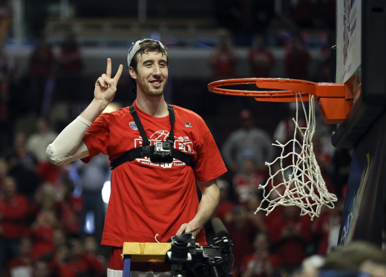 Wisconsin forward Frank Kaminsky flashes the victory sign after cutting down the net following his team's win over Michigan State.