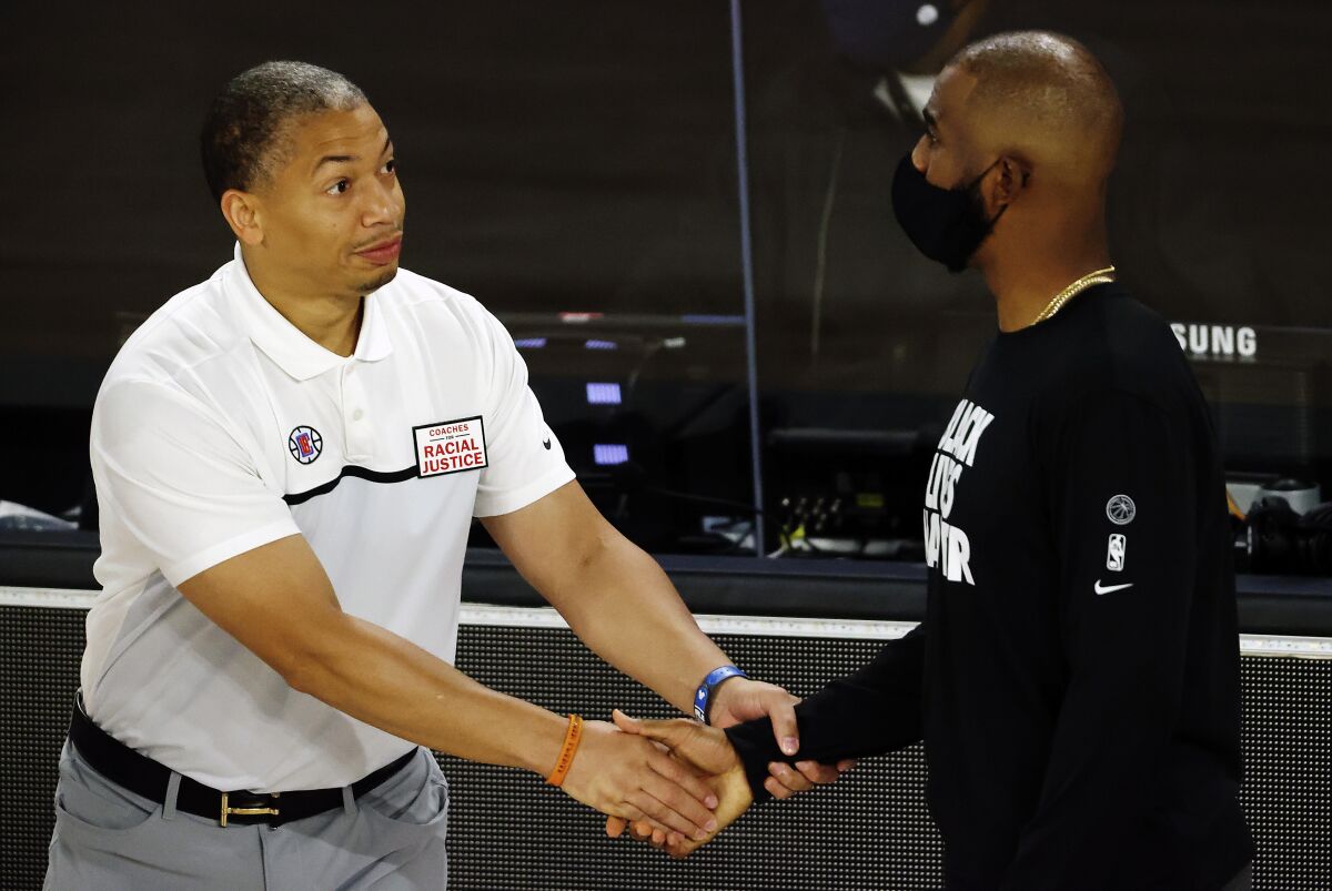 Clippers assistant coach Tyronn Lue greets Thunder point guard Chris Paul before a game in the NBA's bubble on Aug. 14, 2020.