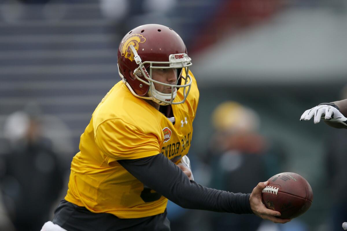 Former USC quarterback Cody Kessler hands off during Senior Bowl practice in Mobile, Ala.