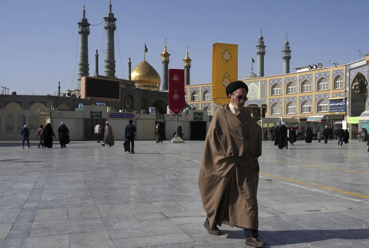 Muslim cleric in front of a shrine in Iranian city of Qom