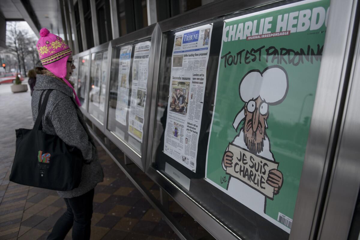 The cover of the French satirical newspaper Charlie Hebdo featuring the Prophet Mohammed is seen displayed with front pages for newspapers from around the world outside the Newseum in Washington on on January 14.