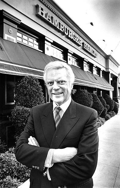 Harry Lewis, founder and president of Hamburger Hamlet, in front of his Brentwood outlet in December 1987.