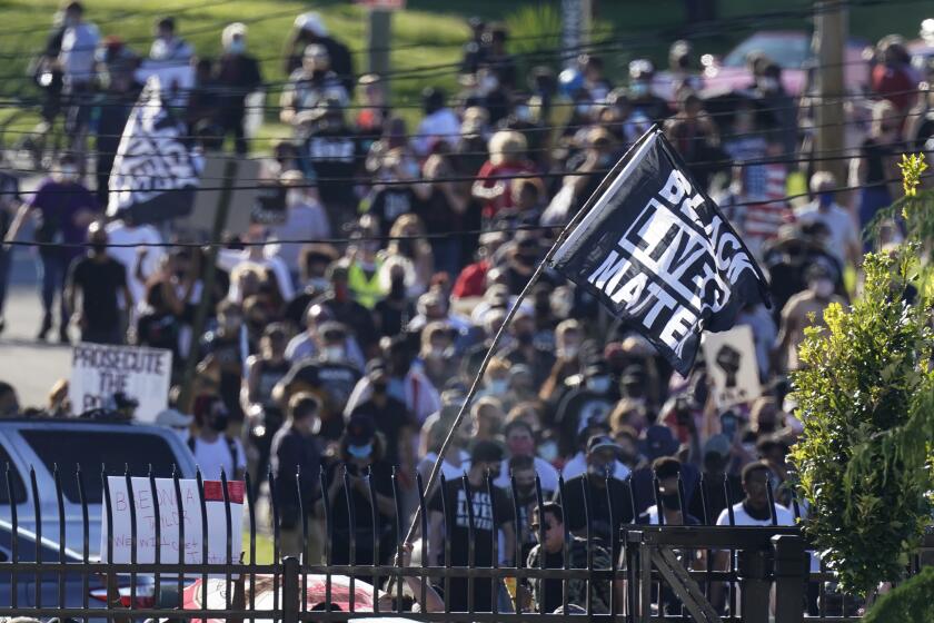 Protesters march past the Churchill Downs racetrack before the 146th running of the Kentucky Derby horse race, Saturday, Sept. 5, 2020, in Louisville, Ky. (AP Photo/Charlie Riedel)