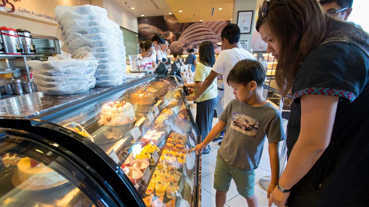 Julian Lai, 8, and his mom, Fiona Kwei, look at the pastries at 85°C Bakery Cafe at Diamond Jamboree.