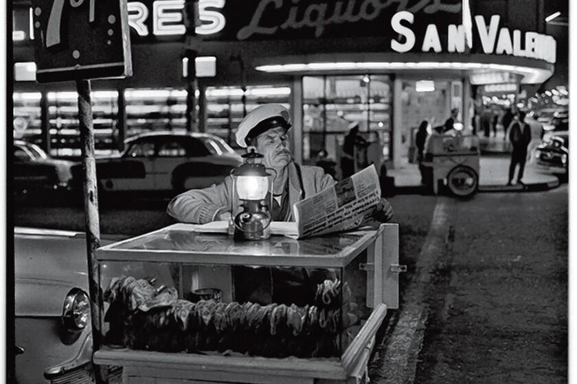 A taco vender catching up on the day’s news until the next customer shows up. Gelatin Silver Print, 1964. Photograph by Harry Crosby. Collection of Paul Ganster
