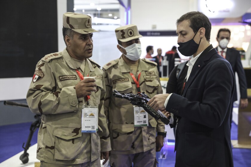 Egyptian army officers talking to a visitor to the Egypt Defence Exhibition 2021 (EDEX), in new Cairo, Egypt, Tuesday, Nov. 30, 2021. Egypt has concluded its second international weapons fair. The country has one of the Middle East’s largest armies, ranks as a top global arms importer and is looking to grow its arsenal while moving away from U.S. suppliers. (AP Photo/Mohamed El-Shahed)