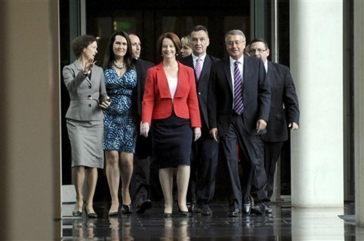 Australian Prime Minister Julia Gillard, center, with supporters for the caucus meeting walks through the parliament house in Canberra, Australia Monday, Feb. 27, 2012. Australian Prime Minister Julia Gillard on Monday has won a resounding victory in a leadership ballot against the party leader she deposed two years ago, Kevin Rudd, and stamped her authority on her government, media reported. (AP Photo/Alan Porritt, Pool)