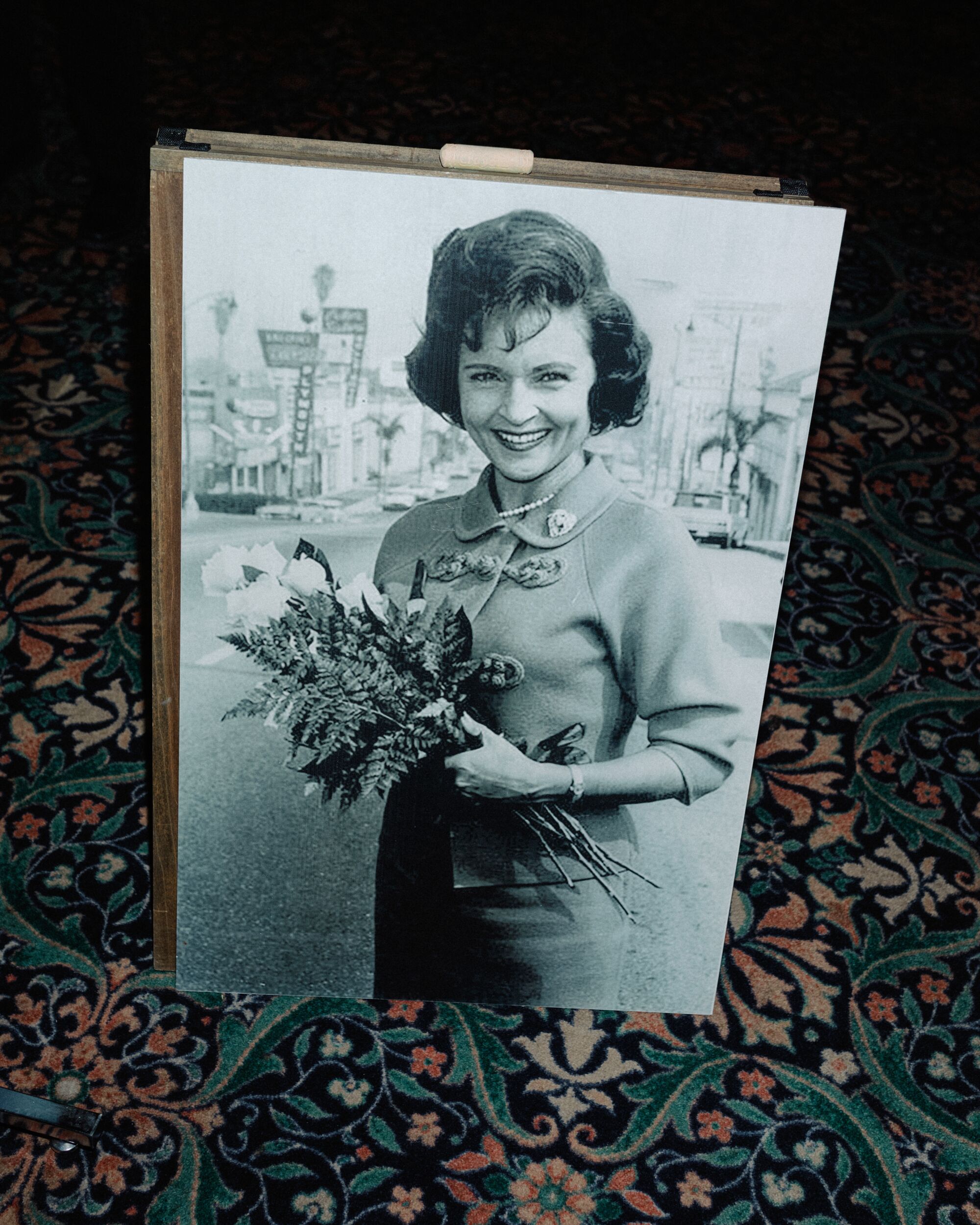 A black-and-white picture of a woman holding flowers.