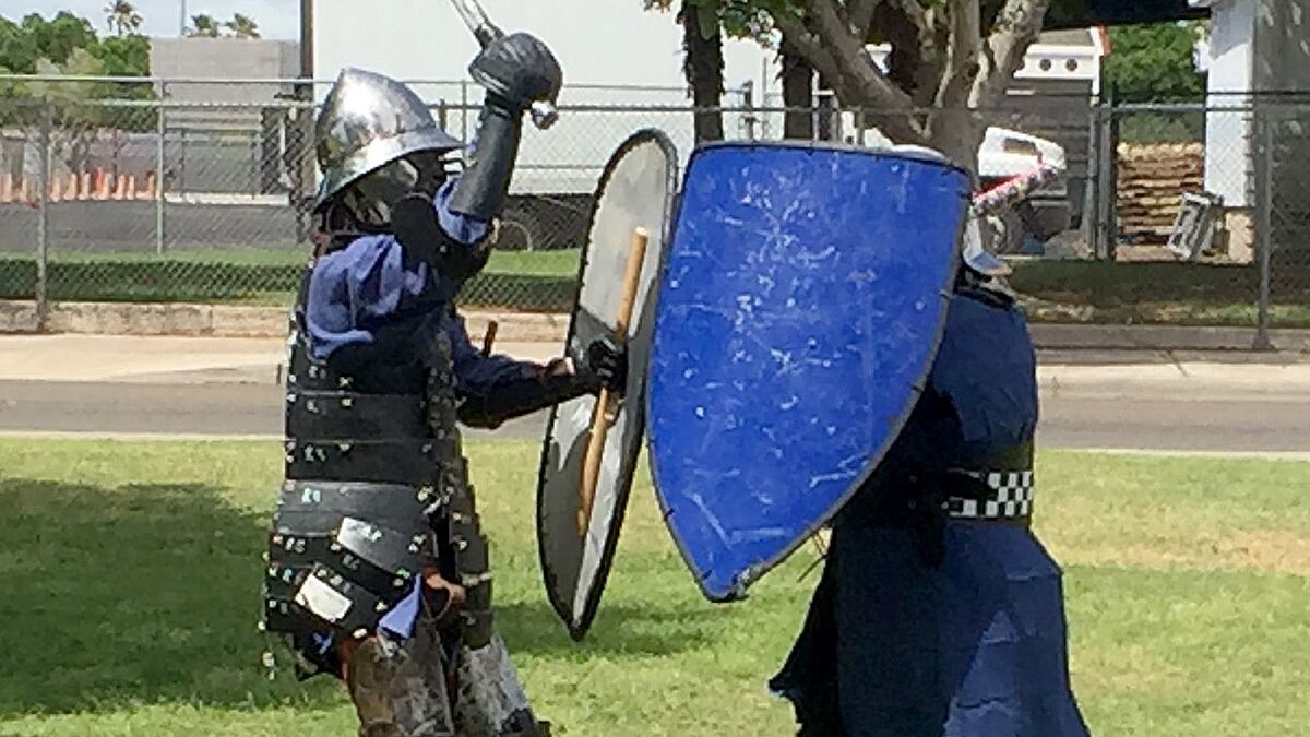As the temperature rises in Yuma in April, members of the Society for Creative Anachronism reenact a medieval sword fight while wearing sweaty period costumes.