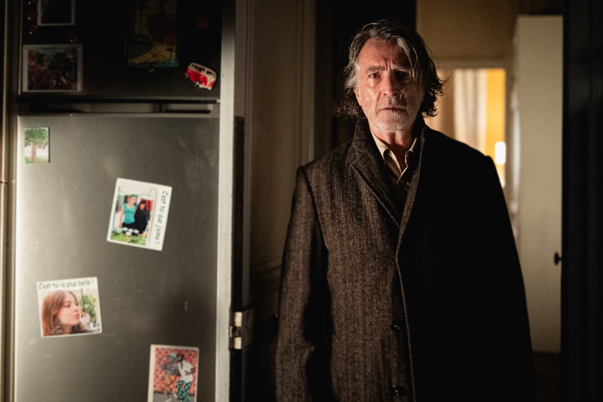 A man stands in an open door looking toward the camera