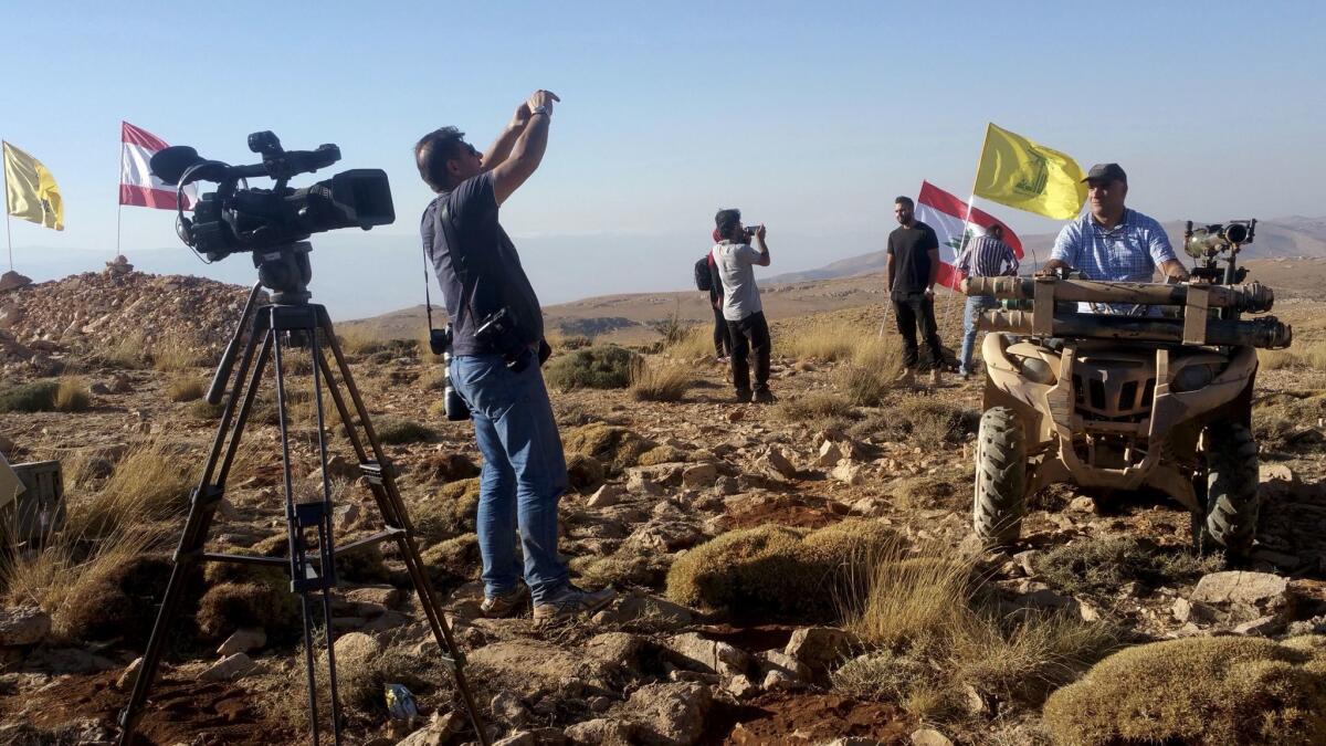 Local journalists pose on a Hezbollah ATV in the Juroud Arsal area between Lebanon and Syria.