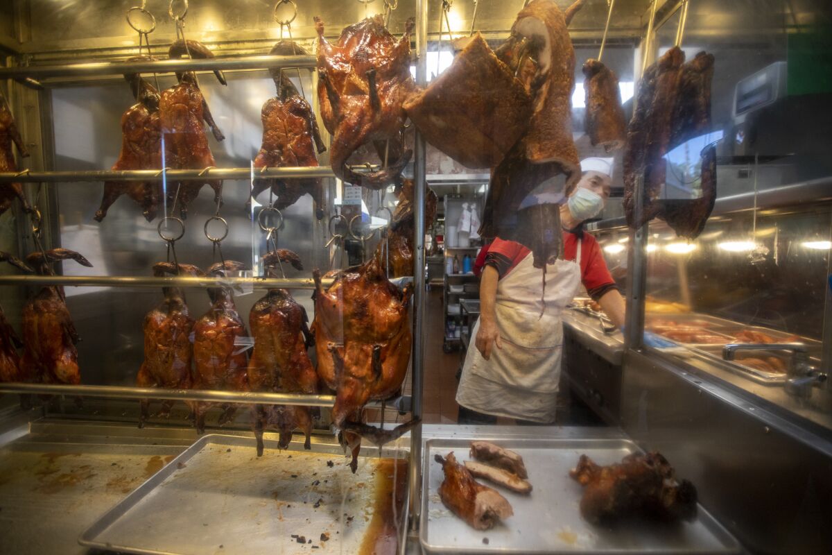 A chef prepares duck at a restaurant.