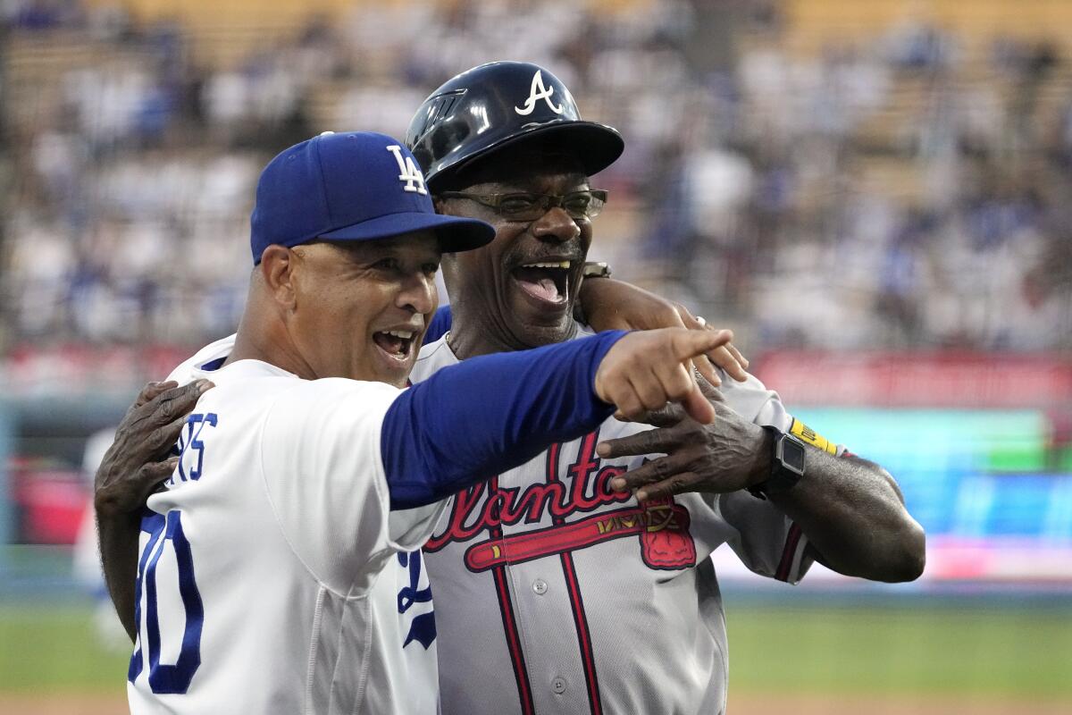 Dave Roberts points and smiles with his arm around Ron Washington.