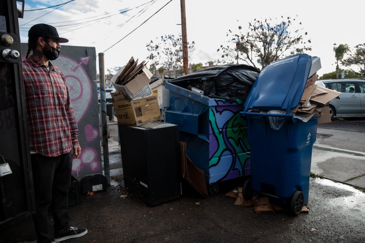 Ron Richie next to the piled up trash behind his coffee shop, GrindHouse, in Chula Vista.