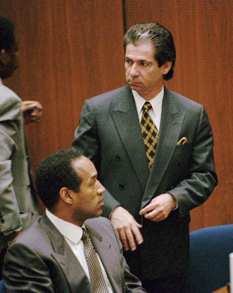 Attorney Robert Kardashian, standing, with O.J. Simpson during a break in during Simpson's double–murder trial, Monday, Feb. 27, 1994 in the Los Angeles.(AP Photo/Rick Meyer, Pool)