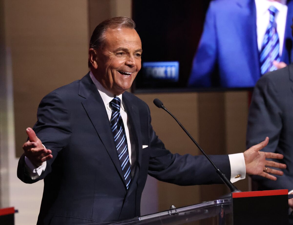 Rick Caruso gestures with open arms while speaking in the mayoral debate at USC on Tuesday.
