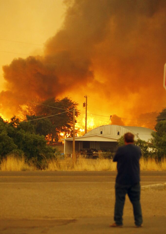 Dean Smith watches as the Yarnell Hill fire encroaches on his home in Glenn Ilah near Yarnell, Ariz.