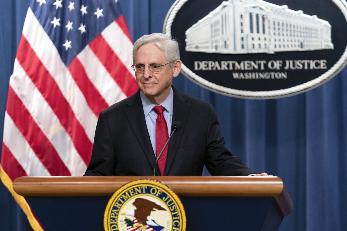 Atty. Gen. Merrick Garland speaks in front of the U.S. flag during a news conference.