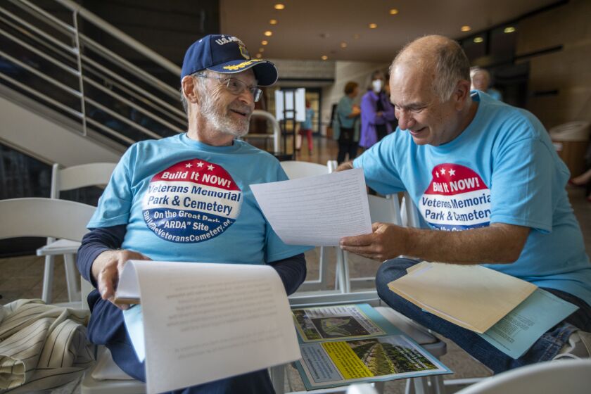 IRVINE, CA - JUNE 22: Gene Kaplin, left, and Don Geller, right, go over notes outside an Irvine City Council meeting in the Irvine City Hall Council Chambers on Tuesday, June 22, 2021 in Irvine, CA. The Irvine City Council is expected to select a site for the Veteran's Cemetery at the Great Park during its first in-person meeting in more than a year on Tuesday. Veteran's groups and residents who have been fighting to build the cemetery at the ARDA site on the former El Toro Marine Base will be showing up in significant numbers. It is expected that the council will not select the ARDA site. (Francine Orr / Los Angeles Times)