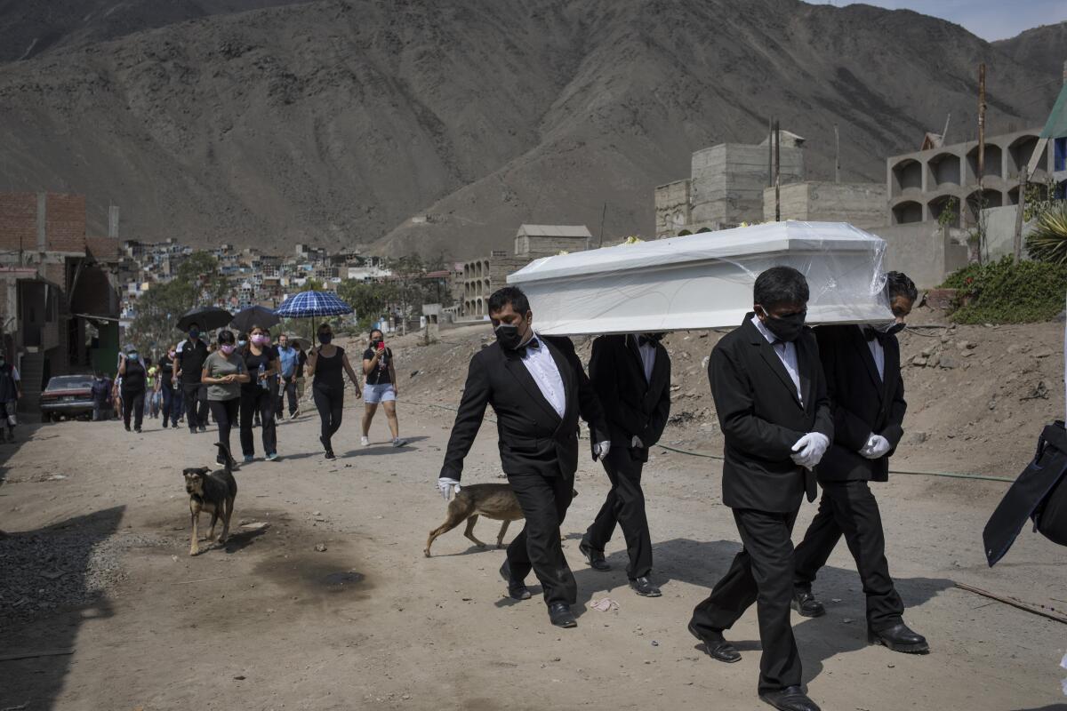 Empleados funerarios trasladan el féretro de Pedro Miguel Infante Vílchez, de 80 años, que falleció de COVID-19