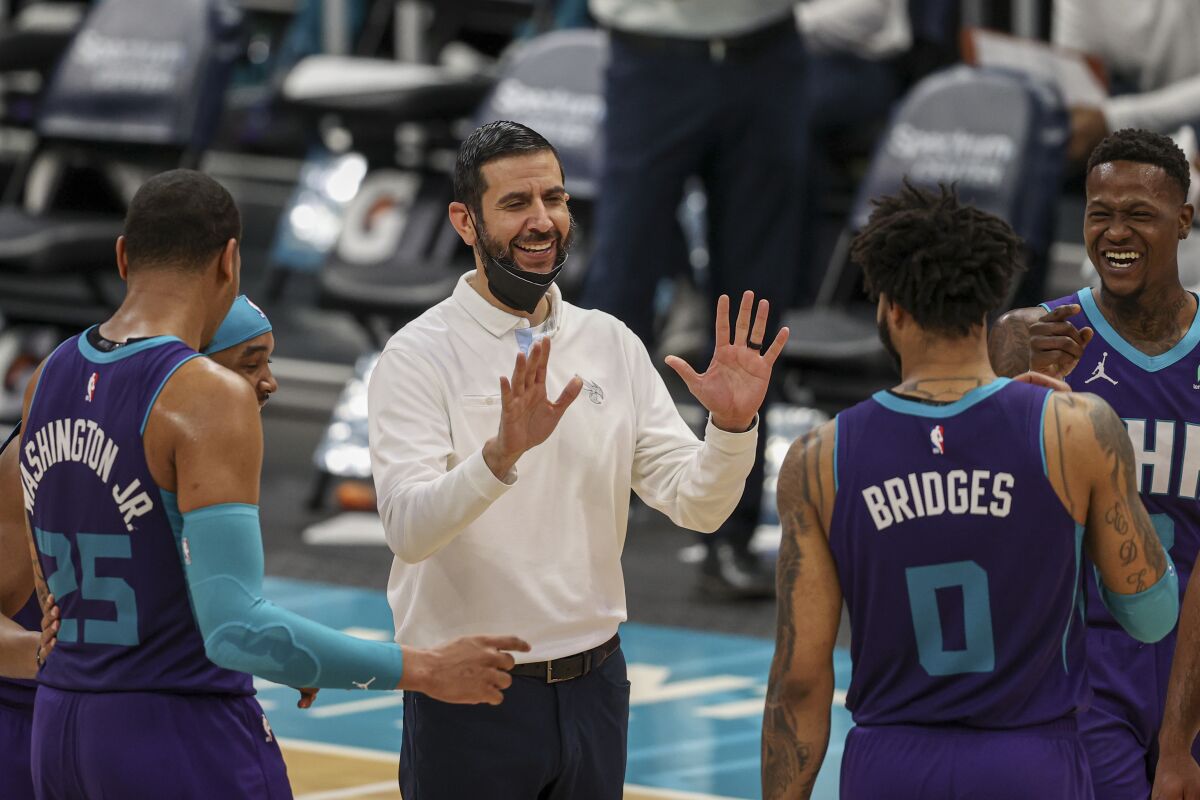 FILE - Charlotte Hornets coach James Borrego, center, laughs with Charlotte Hornets Devonte' Graham, P.J. Washington, Miles Bridges and Terry Rozier during an NBA basketball game against the Atlanta Hawks in Charlotte, N.C., in this Sunday, April 11, 2021, file photo. The Charlotte Hornets have agreed to a multiyear contract extension with coach James Borrego, according to a person with knowledge of the situation. Borrego is expected to sign the deal Monday, Aug. 9, 2021. The person spoke to The Associated Press on condition of anonymity because the team has not yet announced the extension. (AP Photo/Nell Redmond, File)
