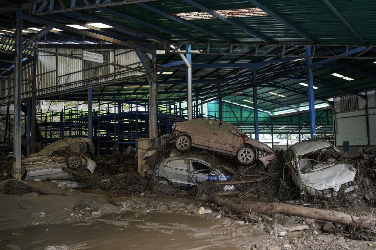 Varios automóviles yacen apliados en un taller luego de que intensas lluvias provocaron inundaciones repentinas 