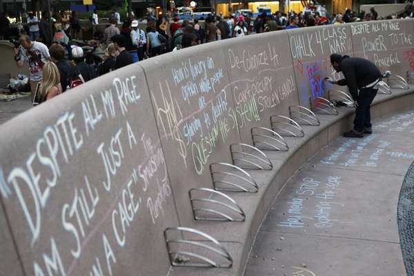 A wall at Pershing Square is covered with messages in chalk.